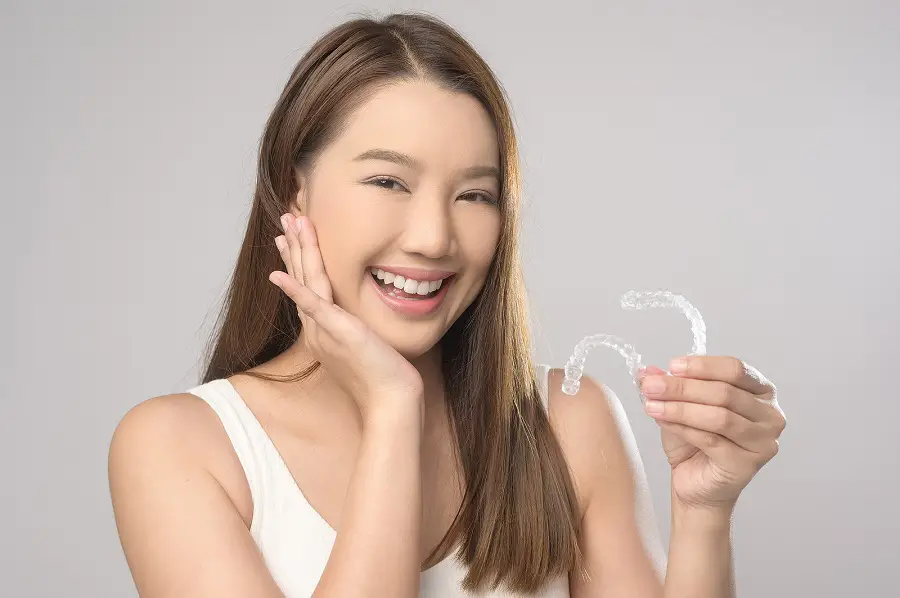 Young-Smiling-Woman-Holding-Invisalign